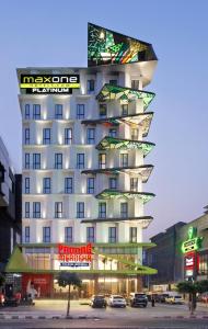 um edifício alto com muitas janelas numa rua da cidade em MaxOne Platinum Hayam Wuruk em Jacarta