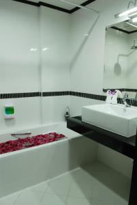 La salle de bains blanche est pourvue d'un lavabo et d'une baignoire. dans l'établissement First Residence Hotel, à Chaweng