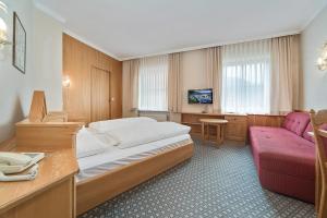 a hotel room with a bed and a couch at Gästehaus Reiter in Golling an der Salzach