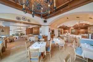 a restaurant with tables and chairs and a chandelier at Gästehaus Reiter in Golling an der Salzach