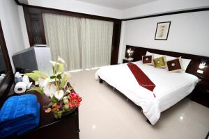 a bedroom with a bed and flowers in a room at First Residence Hotel in Chaweng