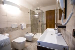 a bathroom with a toilet and a sink and a shower at Appartamenti Cèsa Crepa Neigra in Canazei
