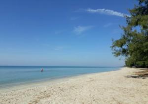 uma vista para uma praia com uma pessoa na água em Mae Rampung Beach House Pool Villa em Rayong