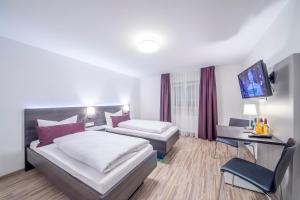 Una habitación de hotel con dos camas y un televisor. en Hotel Nürnberger Hof, en Neumarkt in der Oberpfalz