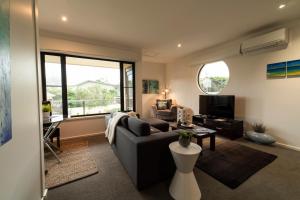 a living room with a couch and a tv at Hilltop Apartments Phillip Island in Cowes