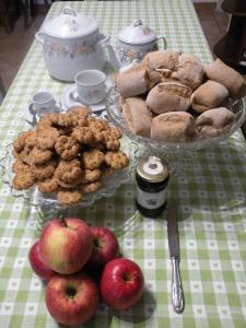 una mesa con manzanas y pasteles en Tetto Nuovo B&B en Cuneo
