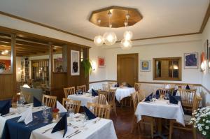 ein Restaurant mit weißen Tischen und Stühlen mit blauen Servietten in der Unterkunft Hotel Berghaus in Wengen