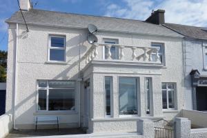 una casa blanca con un banco delante en Sligo Bay Lodge en Rosses Point