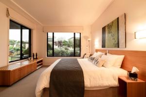 a bedroom with a large bed and large windows at Hilltop Apartments Phillip Island in Cowes