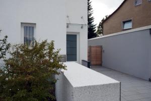 a white house with a driveway and a garage at Messeappartement Unterrath in Düsseldorf