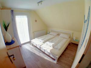 a bedroom with a large white bed in a room at Ferienwohnung Deichstr De Lorenzo in Carolinensiel