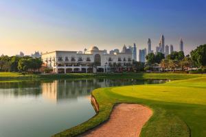 a golf course with a pond in front of a building at Address Montgomerie in Dubai