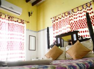 a bedroom with a bed with a red and white wall at A La Villa Creole in Puducherry