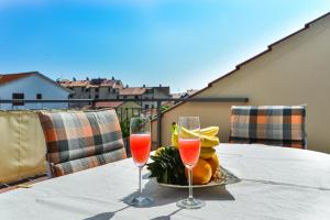 einen Tisch mit zwei Weingläsern und einem Obstteller in der Unterkunft Apartment Lily in Zadar