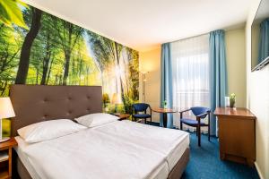 une chambre d'hôtel avec un lit, une table et des chaises dans l'établissement AHORN Seehotel Templin, à Templin