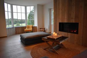een slaapkamer met een bed en een televisie en een tafel bij Cottage in Ardennes - La Maison aux Moineaux - Fays-Famenne in Sohier
