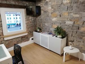 a living room with a stone wall at Casa In Piazza in Cividale del Friuli