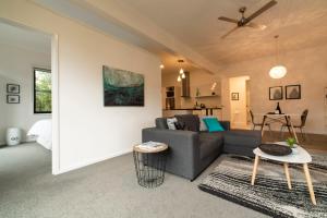 a living room filled with furniture and a tv at Hilltop Apartments Phillip Island in Cowes