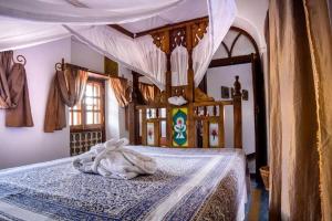 een slaapkamer met een hemelbed bij Zanzibar Coffee House in Zanzibar City