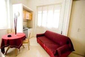 敘拉古的住宿－阿爾可安蒂科住宅酒店，客厅配有红色的沙发和桌子