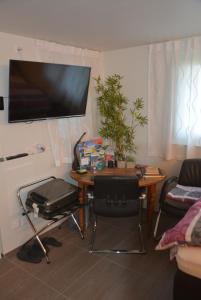 sala de estar con mesa y TV en la pared en BnB Sirnach, en Sirnach