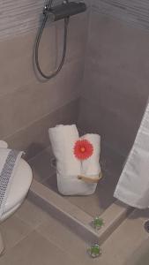a bathroom with a toilet and a flower in a shower at Erato Apartment in Heraklio