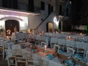 a banquet hall with white tables and chairs and candles at Masseria Don Sante in Fasano +46 photos