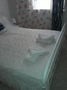 - un lit blanc avec des draps blancs et une fenêtre dans l'établissement Αnna's Home!!!Holidays in beautiful Athens, à Athènes