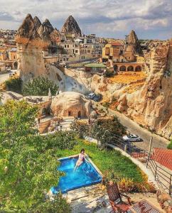 a person in a swimming pool at a resort at Traveller's Cave Hotel in Göreme