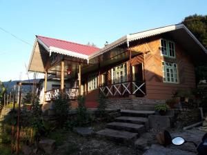 una casa in legno con scale di fronte di Vamoose Soshing Homestay a Ravangla