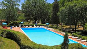 a large swimming pool with lounge chairs and umbrellas at Glamping Siena in Siena