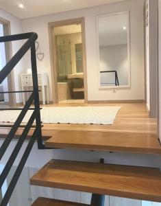 a room with a mirror and a wooden floor at Praia da California Apartment in Sesimbra