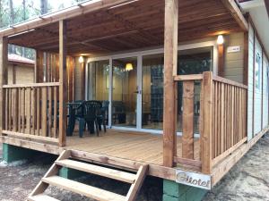 eine abgeschirmte Veranda eines Hauses mit einem Tisch in der Unterkunft Odeceixe Bungalow-Parque de Campismo Sao Miguel in Odeceixe