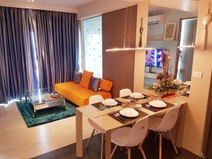 a living room with a table and a yellow couch at Veranda Residence by VS in Na Jomtien