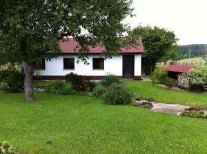 a white house with a red roof in a yard at U Kryštofa in Luže