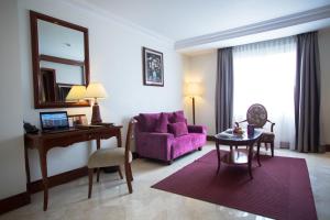 sala de estar con sofá púrpura y mesa en Arion Suites Hotel Kemang, en Yakarta