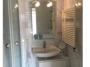 ein Bad mit einem Waschbecken und einem Spiegel in der Unterkunft Ostseeresidenz App 2 in Pelzerhaken