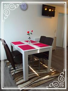 a white table with a vase of flowers on it at Ferienwohnung Schnell Bad Saulgau in Bad Saulgau