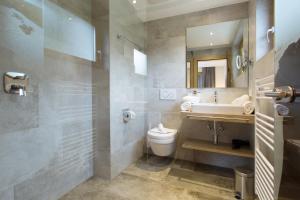 a bathroom with a sink and a toilet and a mirror at Apart Val Sula in Sankt Anton am Arlberg