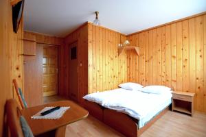 a bedroom with a bed and a table in it at Dom Wypoczynkowy Halina in Biały Dunajec