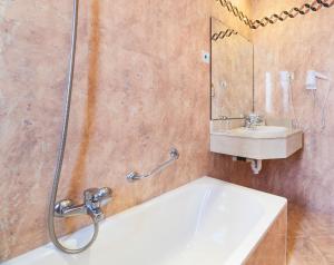 uma casa de banho com uma banheira, um lavatório e um chuveiro em Globales Reina Cristina em Algeciras
