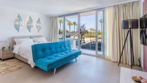 a bedroom with a bed and a blue couch at The Hype Beachhouse in Playa de Palma