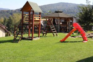 a playground with a slide and a play structure at Domki pod Kiczerką w Solinie in Solina
