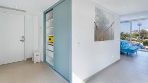 a living room with a blue couch and a glass wall at The Hype Beachhouse in Playa de Palma