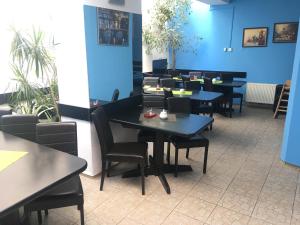 comedor con mesas y sillas y paredes azules en Aladin Praha, en Praga