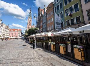 a city street with buildings and a clock tower at Hotel Holland House Old Town in Gdańsk