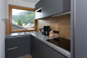 a kitchen with a sink and a window at Apart Val Sula in Sankt Anton am Arlberg