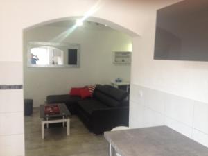 a living room with a black couch and a table at appartement en rez de villa in Gattières