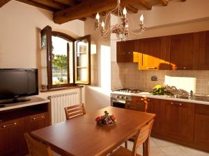 TordandreaにあるBelvilla by OYO Spelloのキッチン(木製テーブル、テレビ付)