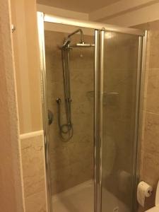 La salle de bains est pourvue d'une douche avec une porte en verre. dans l'établissement Milano centro - Heart of BRERA, à Milan